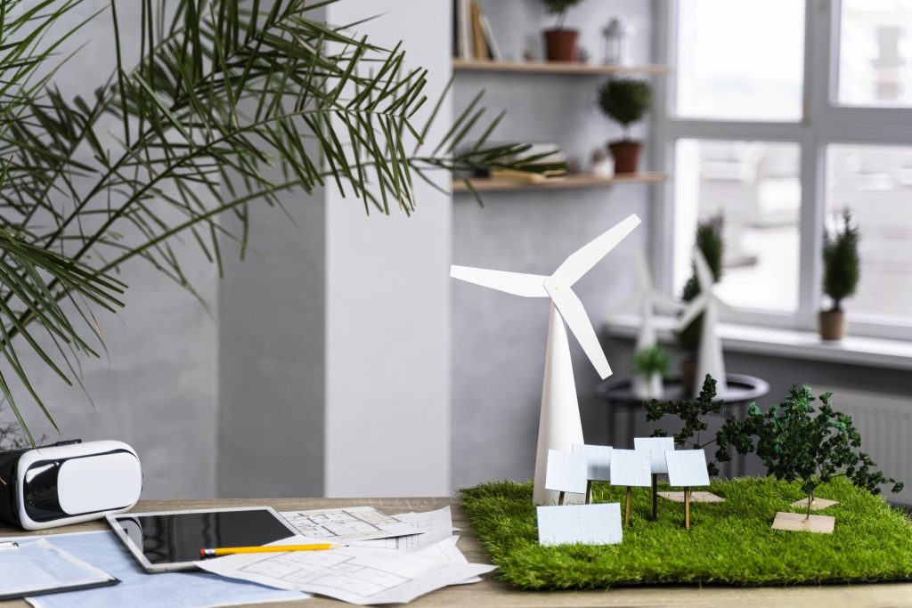 Sala com papeis e maquetes de projetos sustentáveis